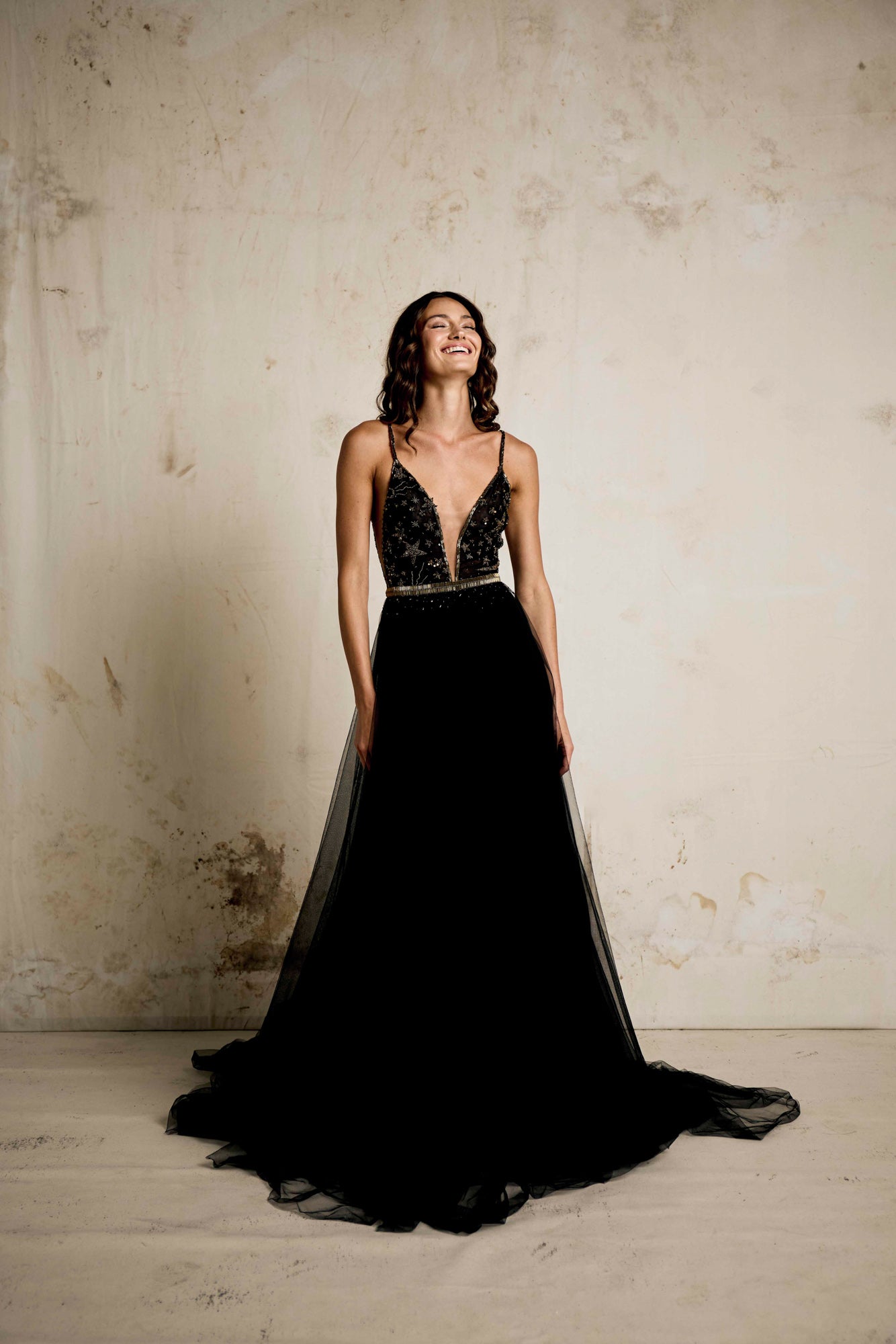An alternative wedding gown in black with  celestial beaded detailing. V neck dress with star and moon detailing and a full soft tulle skirt with gold detailing and beaded belt.  