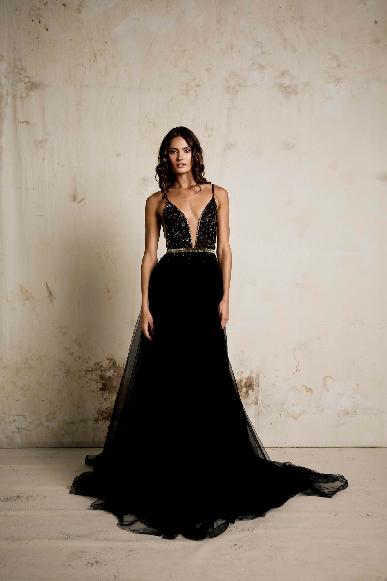 An alternative wedding gown in black with  celestial beaded detailing. V neck dress with star and moon detailing and a full soft tulle skirt with gold detailing and beaded belt.  