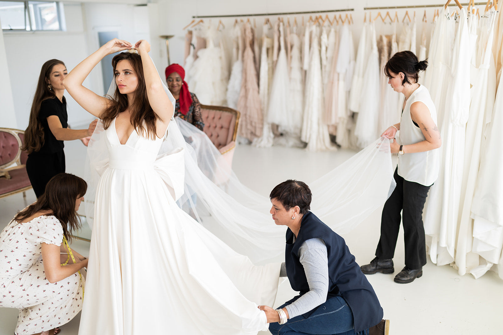 a bride trying on wedding dresses and veils with a bridal consultant